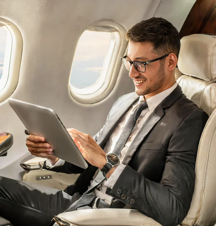 A passenger in a business jet seat viewing the CSS-100 moving map on a tablet